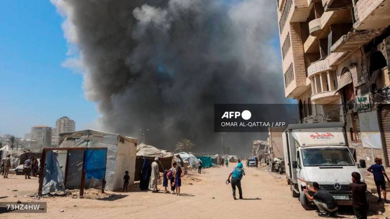 People watch as smoke billows during an Israeli strike on the Mushtaha Tower in Gaza City on September 5, 2025, amid the war between Israel and the Hamas militant movement. - AFP