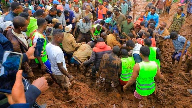 Residents dig to recover the dead body of a victim of the landslide following heavy rains that buried people in Gofa zone, Southern Ethiopia - AFPpix