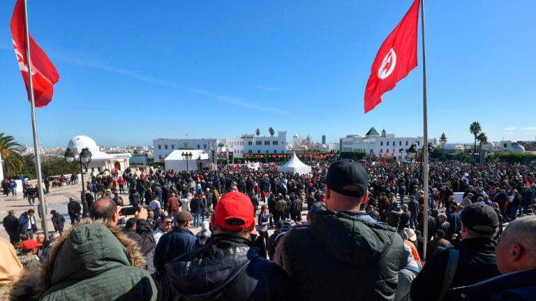 Trade unionists raise national flags and placards as they take to the streets of Tunis to protest against a proposed legislation that will grant the government sweeping powers over NGOs, on March 2, 2024/AFPPix