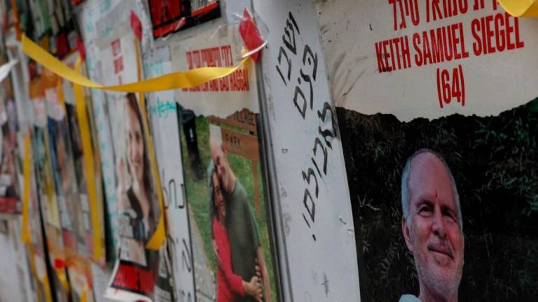 A view of a banner depicting Keith Siegel, who is a dual U.S. citizen seized during the October 7 attack on Israel and taken hostage into Gaza, amid the ongoing conflict between Israel and Hamas, is seen with other images of hostages in Tel Aviv, Israel, April 28, 2024/REUTERSPix