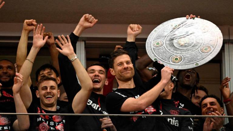 Bayer Leverkusen’s Spanish head coach Xabi Alonso celebrates with a mock-up of the Bundesliga trophy with his players after the German first division Bundesliga football match Bayer 04 Leverkusen v Werder Bremen in Leverkusen, western Germany, on April 14, 2024/AFPPix