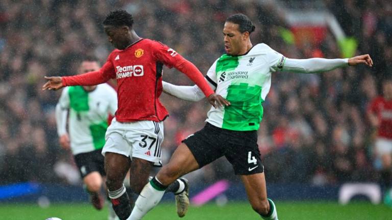 Manchester United’s English midfielder #37 Kobbie Mainoo (L) vies with Liverpool’s Dutch defender #04 Virgil van Dijk (R) during the English Premier League football match between Manchester United and Liverpool at Old Trafford in Manchester, north west England, on April 7, 2024/AFPPix