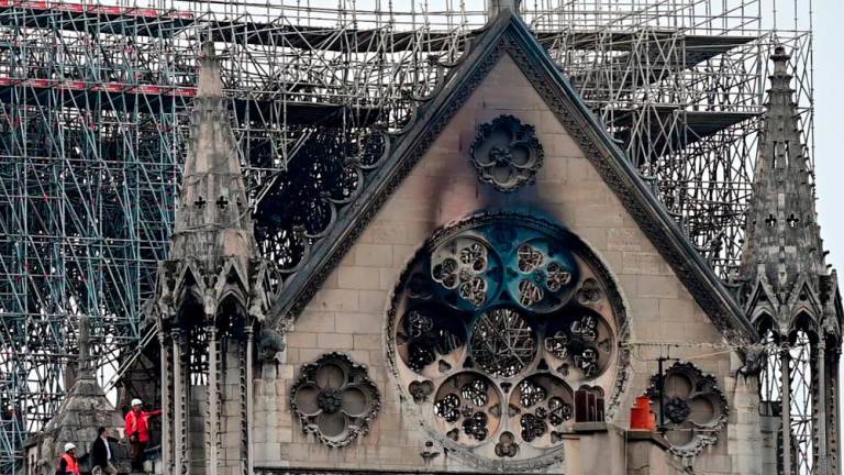 Filepix: Inspectors are seen on the roof of the landmark Notre-Dame Cathedral in central Paris on April 16, 2019, the day after a fire ripped through its main roof/AFPPix