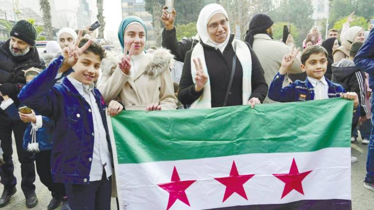 Syrians flash the V for victory sign as they celebrate in the central city of Homs on Monday, after rebel forces entered Syria’s third city overnight. – AFPPIC