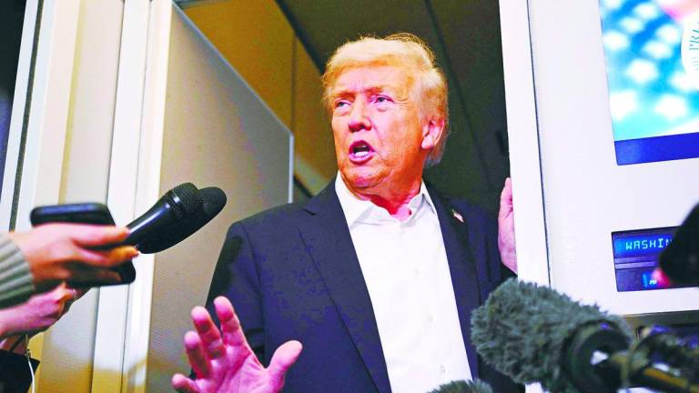 Trump speaks with the press on board Air Force One in Mildenhall, Suffolk yesterday after he and regional leaders signed a declaration to cement a ceasefire in Gaza. – AFPPIX