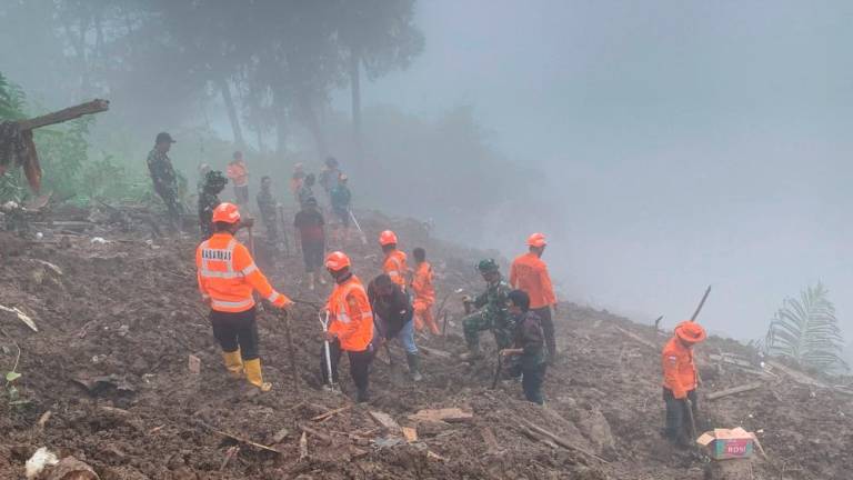 This handout photo taken and released on April 15, 2024 by the National Search and Rescue Agency (BASARNAS) shows rescuers searching for missing people at the site of a landslide that killed at least 18 people and left two missing in Tana Toraja, South Sulawesi/AFPPix