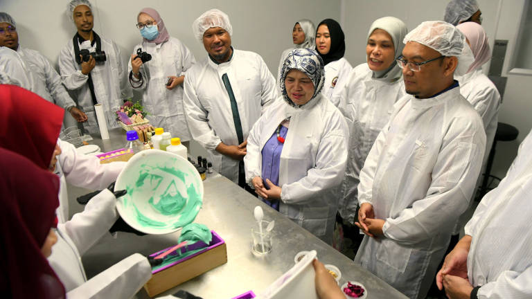 Deputy Minister of Rural and Regional Development, Datuk Rubiah Wang (second from right), observes the soap-making process during a visit to a factory at the Launch Ceremony of the TVET@KKDW 2025 Green Practices initiative at the MARA Higher Skills College today. – BERNAMA