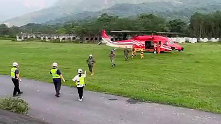 This screengrab from handout video from Taiwan’s Central Emergency Operation Center taken and released on April 4, 2024 shows workers disembarking from a helicopter after being rescued from a quarry in Hualien, following a major earthquake in Taiwan’s east/AFPPix- TAIWAN’S CENTRAL EMERGENCY OPERATIONS CENTER
