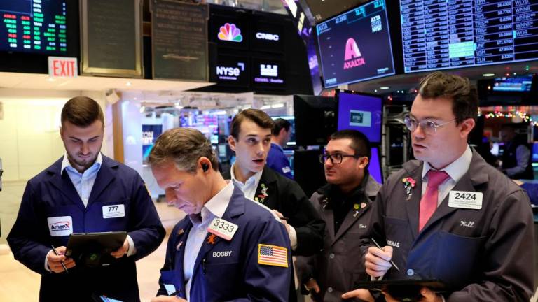 Traders gathering at the post that trades Alaska Airlines stock on the floor at the New York Stock Exchange on Monday. – Reuterspic