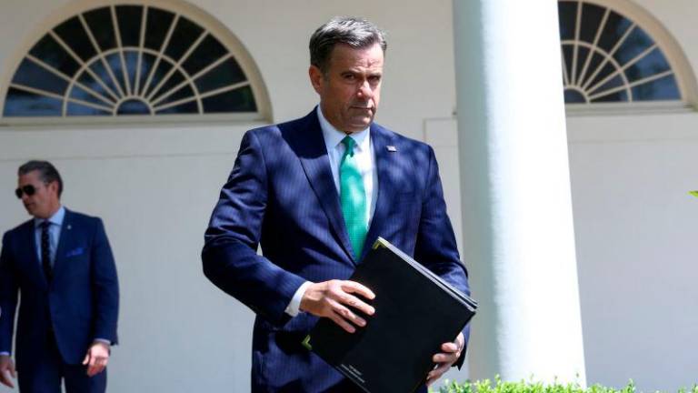 U.S. Central Intelligence Agency Director John Ratcliffe walks during a National Day of Prayer event, with Defense Secretary Pete Hegseth in the background, in the Rose Garden at the White House in Washington, D.C., U.S., May 1, 2025. REUTERSpix