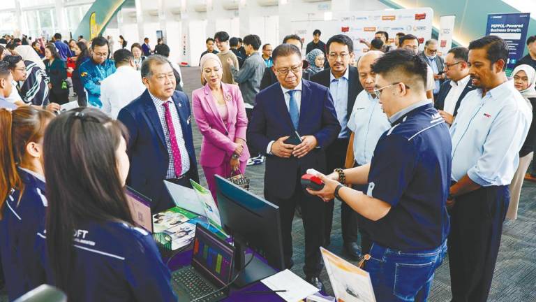 Julaihi, accompanied by Ugak and MDEC representatives, visiting exhibition booths showcasing digital solutions for MSMEs in conjunction with the MD Business Digitalisation Initiative launch in Kuching.