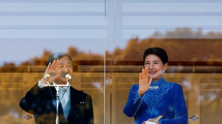 Japanese Emperor Naruhito and Empress Masako wave their hands to well-wishers from a balcony at the Imperial Palace in Tokyo, Japan February 23, 2025. REUTERSpix