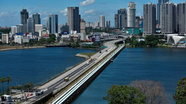 FILE PHOTO: A bus plies the causeway between Singapore and Malaysia, Singapore November 29, 2021. REUTERS/Caroline Chia/File Photo