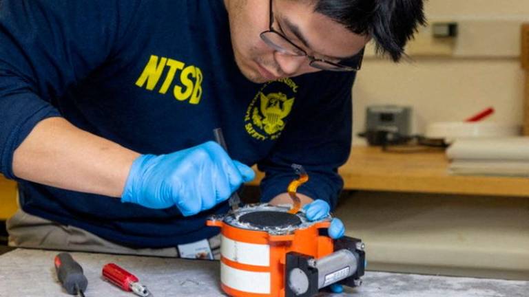 An NTSB investigator works on the black box of American Eagle flight 5342, which was involved in a collision with a Black Hawk helicopter, at an unknown location in this undated handout image released on January 30, 2025. NTSB/Handout via REUTERSpix