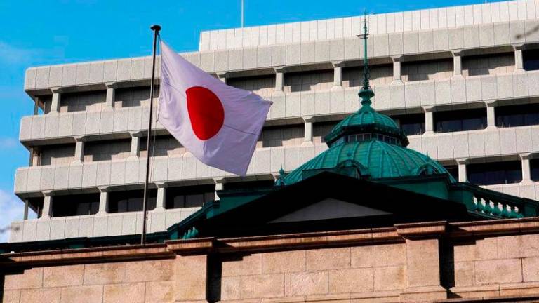 The national flag flutters at the Bank of Japan headquarters in Tokyo on January 23, 2024. - AFPPIX