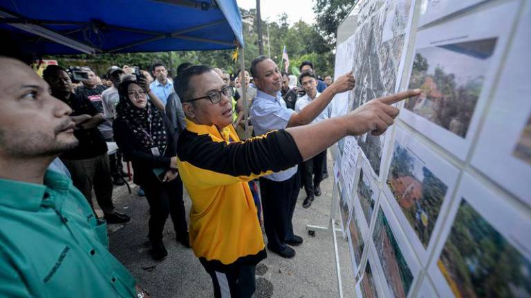 Menteri Besar Selangor Datuk Seri Amirudin Shari melihat gambar dan pelan kejadian kawasan tanah runtuh di Jalan E6, Taman Melawati, hari ini. - fotoBERNAMA