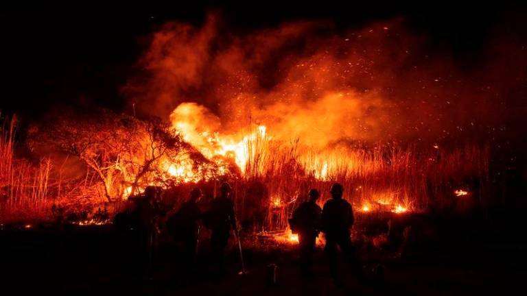 Firefighters monitor and control the spread of the Auto Fire in Oxnard, North West of Los Angeles, California, on January 13, 2025. - AFPPIX