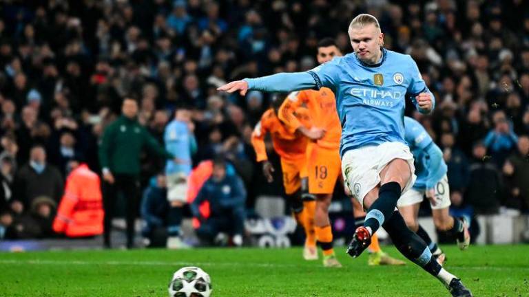 Manchester City's Norwegian striker #09 Erling Haaland shoots a penalty kick and scores his team second goal during the UEFA Champions League football match between Manchester City and Real Madrid at the Etihad Stadium in Manchester, north west England, on February 11, 2025. - AFPPIX