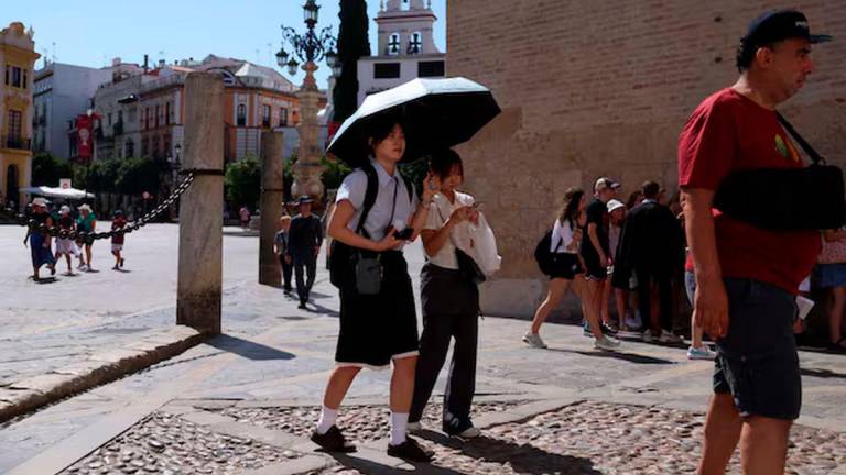 People walk during a heatwave, in Seville, Spain, July 2, 2025. REUTERS/Claudia Greco