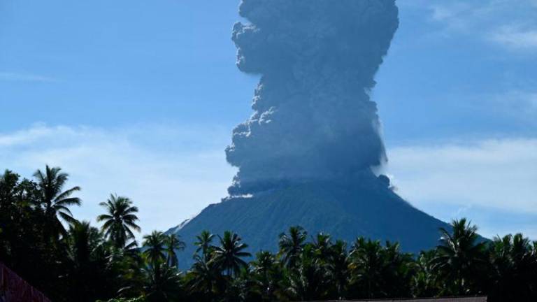 This handout photo taken and released by the Center for Volcanology and Geological Hazard Mitigation (PVMBG) on May 13, 2024 shows Mount Ibu spewing thick smoke in Indonesia's North Maluku Province. - AFPPIX