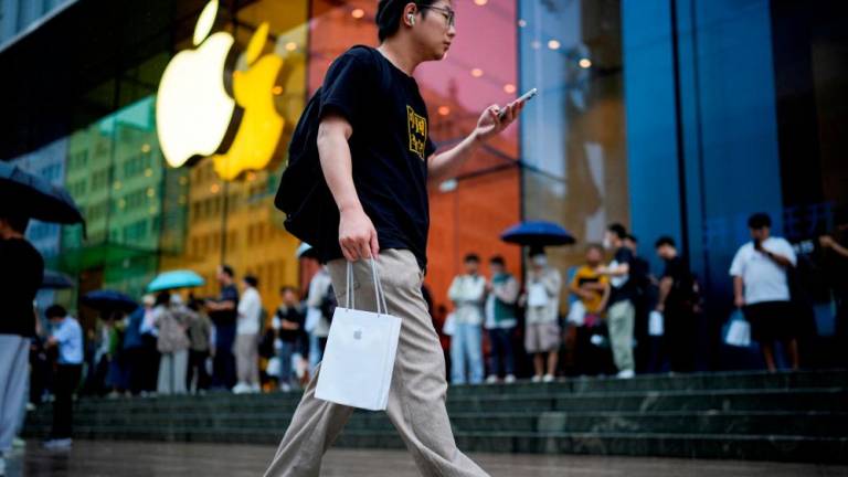 A man holds a bag with a new iPhone inside it in Shanghai, China. – Reuterspic