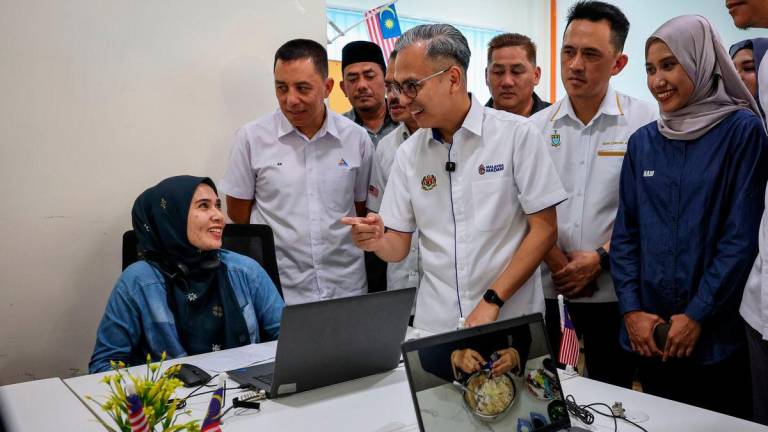 Menteri Komunikasi Datuk Fahmi Fadzil (tengah) beramah mesra dengan komuniti setempat selepas merasmikan Pusat Sebaran Maklumat Nasional (NADI) Penanti hari ini - fotoBERNAMA