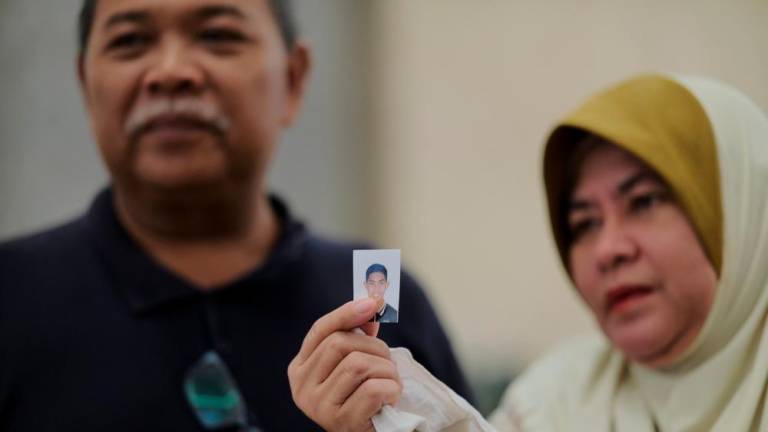 The father of the murder victim, Zulfarhan Osman Zulkarnain, who was also a former student of the National Defense University of Malaysia (UPNM), Zulkarnain Idros, and his wife, Hawa Osman, show a picture of their late son after the Court of Appeal sentenced six former UPNM students to death by hanging at the Istana Putrajaya judiciary today - BERNAMApix