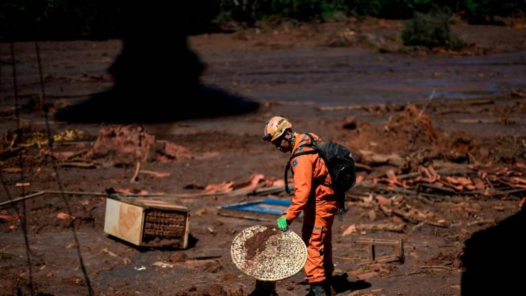 Firefighter captain Leonard Farah rescues personal belongings from houses destroyed by the mudslide, one month after the rupture of a tailings dam of mining company Vale in Corrego do Feijao, near Brumadinho, in the Brazilian state of Minas Gerais, on February 22, 2019/AFPPix