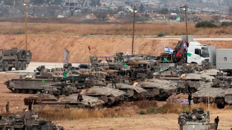 Israeli troops deploy on Israel’s border with the Gaza Strip (background). AFPpix