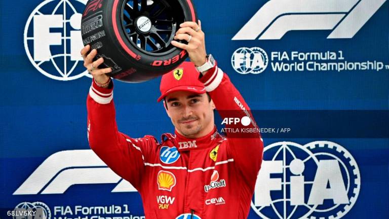 Ferrari’s Monegasque driver Charles Leclerc reacts after he won the pole position during the qualifying session of the Formula One Hungarian Grand Prix at the Hungaroring circuit in Mogyorod, near Budapest, Hungary, on August 2, 2025. (Photo by Attila KISBENEDEK / AFP)