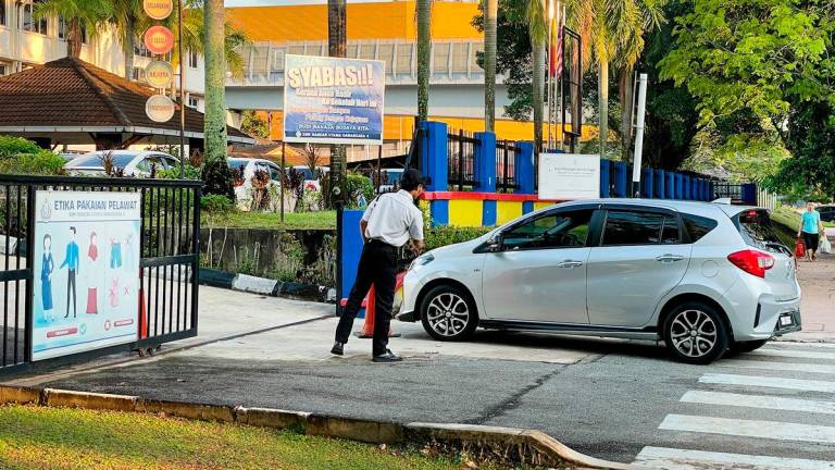 Security presence at the school yesterday as the community grapples with the tragedy that claimed a student’s life. – ADIB RAWI YAHYA/THESUN