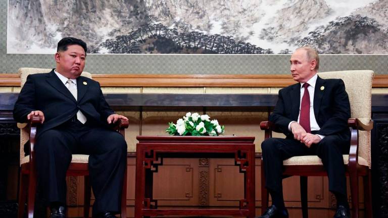 In this pool photograph distributed by the Russian state agency Sputnik, Russian President Vladimir Putin and North Korean State Chairman Kim Jong Un (L) meet after attending a military parade marking the 80th anniversary of victory over Japan and the end of World War II, in Beijing’s Tiananmen Square on September 3, 2025. - Alexander Kazakov / POOL / AFP