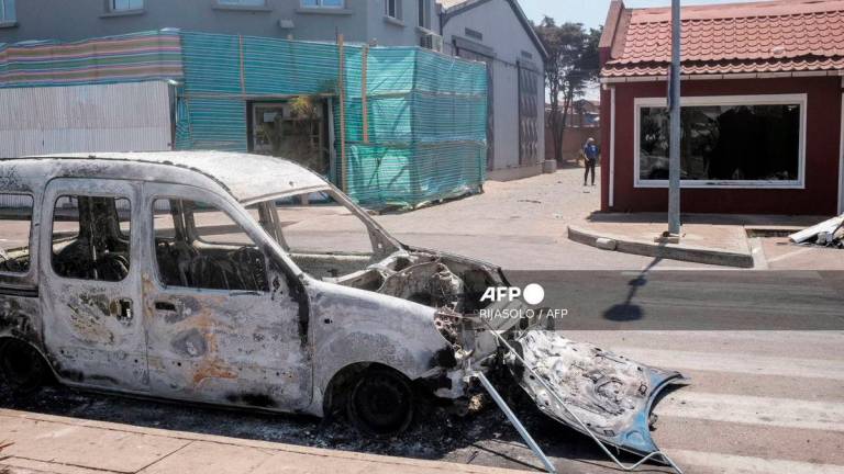 A general view of an empty street with a burned car a day after a demonstration against repeated water and electricity outages in Antananarivo on September 26, 2025. - AFP