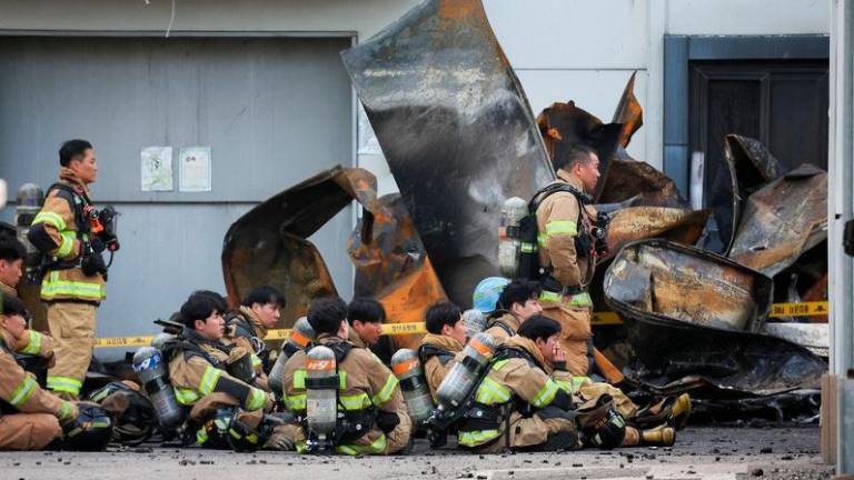 Firefighters take a break as rescue work continues following a deadly fire at a lithium battery factory owned by South Korean battery maker Aricell - REUTERSpix