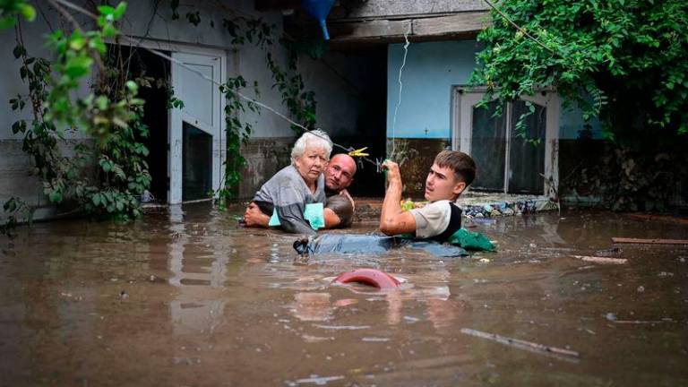 Local residents rescue an elderly man (C) from the rising flood waters in the Romanian village of Slobozia Conachi - AFPpix