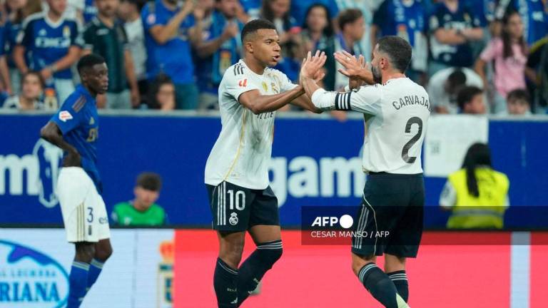 Real Madrid's French forward #10 Kylian Mbappe celebrates scoring his team's first goal with Real Madrid's Spanish defender #02 Dani Carvajal during the Spanish league football match between Real Oviedo and Real Madrid CF at Carlos Tartiere Stadium in Oviedo on August 24, 2025. - AFP
