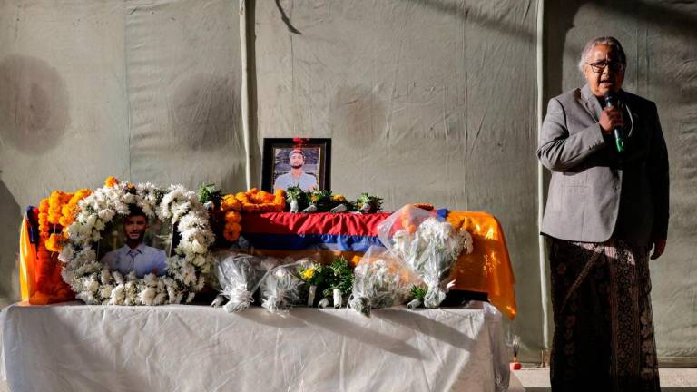 Nepal’s interim Prime Minister Sushila Karki delivers a eulogy as she stands next to the coffin of deceased hostage Bipin Josh. REUTERS/Navesh Chitrakar
