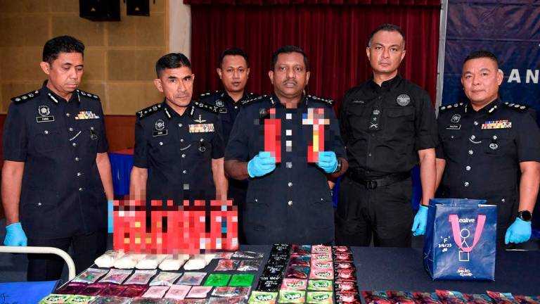 Ketua Polis Selangor Datuk Hussein Omar Khan (tiga, kanan) menunjukkan minuman yang mengandungi dadah ketika sidang media berhubung kejayaan anggota polis menumpaskan sindiket pengedaran dadah dikenali “Geng Alstonia” di Ibu Pejabat Polis Kontinjen Selangor hari ini. fotoBERNAMA