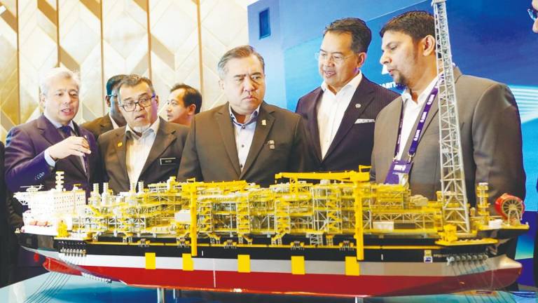 Loke (centre) being briefed on one of the exhibits at the Malaysia Maritime Week 2025 today. – AMIRUL SYAFIQ/THESUN