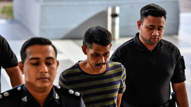 Izat Saini @ Zaini, 43, didakwa di Mahkamah Majistret atas pertuduhan menggunakan kekerasan jenayah terhadap dua penjawat awam. - BERNAMA