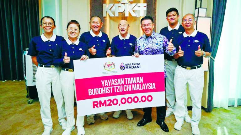 Nga (third from right) and the Tzu-Chi representatives with a mock cheque for the RM20,000. – Pic Courtesy of Housing and Local Government Ministry