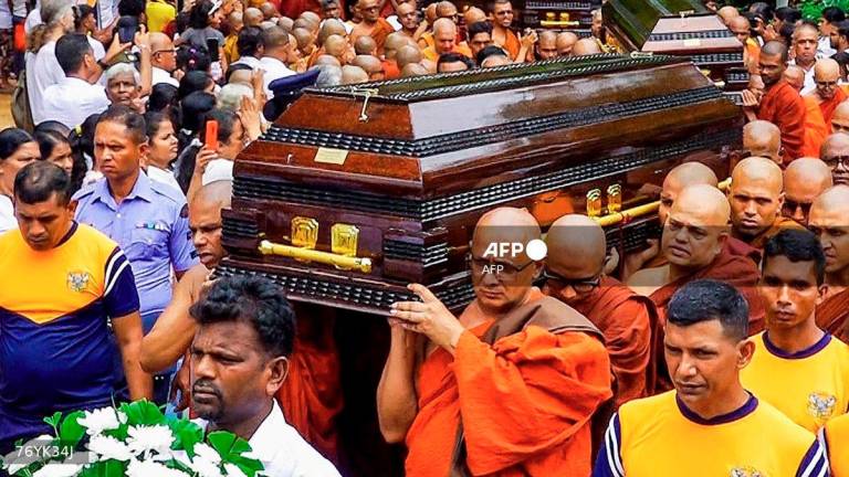 Buddhist monks carry coffins of fellow monks during a funeral ceremony at the Na Uyana Monastery in Melsiripura on September 27, 2025. - AFP
