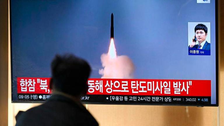 A man watches a television screen showing a news broadcast with file footage of a North Korean missile test, at a train station in Seoul - AFPpix