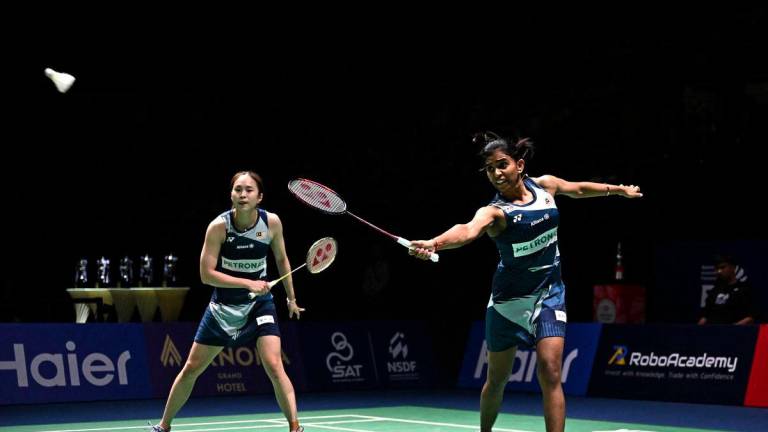 Thinaah Muralitharan (R) hits a return as teammate Pearly Tan (L) looks on against South Korea’s Jeong Na-eun and Lee Yeon-woo during the women’s doubles final at the 2025 Thailand Open badminton tournament in Bangkok on May 18, 2025. - AFPPIX