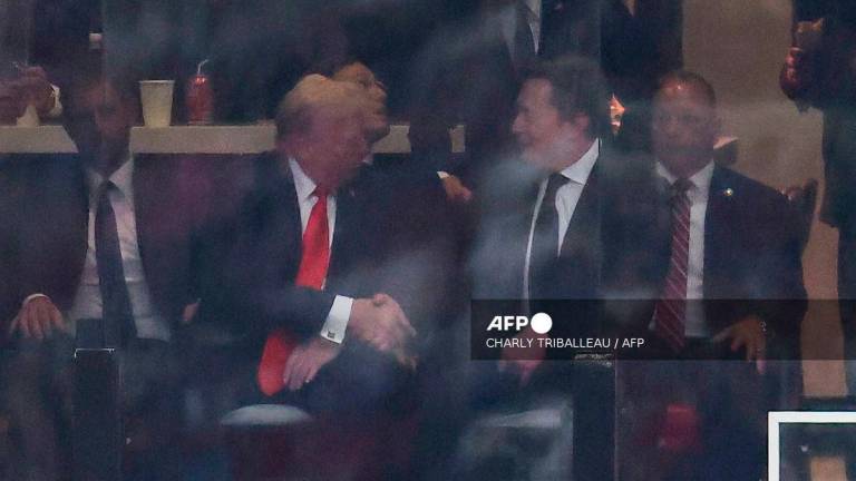 US President Donald Trump and Tesla CEO Elon Musk shake hands during the public memorial service for right-wing activist Charlie Kirk at State Farm Stadium in Glendale, Arizona, on September 21, 2025. - AFP
