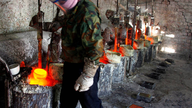 Ren Limin, a worker at the Jinyuan Company's smelting workshop, prepares to pour the rare earth metal Lanthanum into a mould near the town of Damao in China's Inner Mongolia Autonomous Region October 31, 2010. - REUTERS