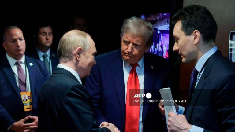 In this pool photograph distributed by the Russian state agency Sputnik, US President Donald Trump (C) and Russian President Vladimir Putin (L) shake hands after delivering a joint press conference following a US-Russia summit on Ukraine at Joint Base Elmendorf-Richardson in Anchorage, Alaska, on August 15, 2025. - POOL via AFP