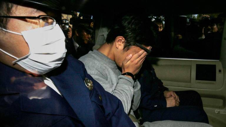 This file photo taken on November 1, 2017 shows suspect Takahiro Shiraishi (C) covering his face with his hands - AFPPix