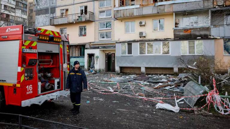 A firefighter works at a site of an apartment building hit by a Russian drone strike, amid Russia’s attack on Ukraine, in Kyiv - REUTERSpix