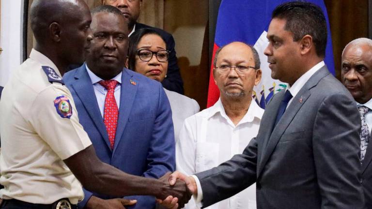 Haiti’s former National Palace Security Chief Vladimir Paraison shakes hands with President of Haiti’s Transitional Presidential Council (CPT) Laurent Saint-Cyr, after being officially named National Police Chief. Reuterspix
